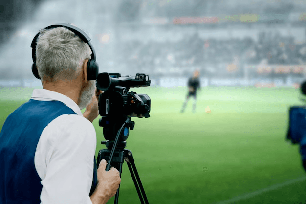 Sports broadcaster filming a match from the sidelines